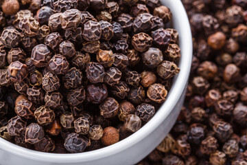 fragrant black pepper on white acrylic background