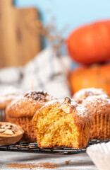 Freshly baked pumpkin muffins and walnuts, cinnamon and nutmeg. Autumn or winter food. Sweet seasonal pumpkin baked goods.