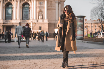 Fototapeta premium portrait of stylish gorgeous woman in coat outdoors drinking coffee to go