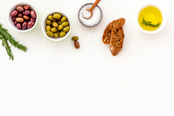 Fototapeta na wymiar Top view of olives, olive oil, bread on yellow table top view copy space