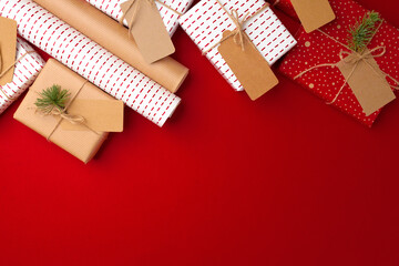 Christmas preparations concept with wrapping paper, gift boxes on red background - obrazy, fototapety, plakaty