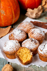 Freshly baked pumpkin muffins and walnuts, cinnamon and nutmeg. Autumn or winter food. Sweet seasonal pumpkin baked goods.