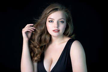 Naklejka premium Young beautiful woman with natural makeup on black background. Beauty & Skin care concept. Plus size model.