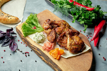 Georgian cuisine dish chicken tapaka on a wooden board. Grilled chicken. Top view