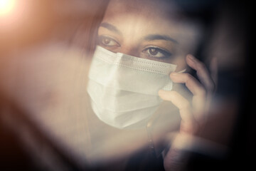 Woman talking on the mobile phone while wearing a mask