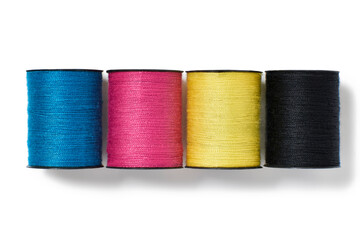 cyan,magenta,yellow and black cotton reels isolated on white background