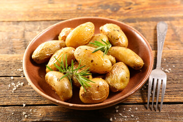 roasted potato and rosemary on wood background