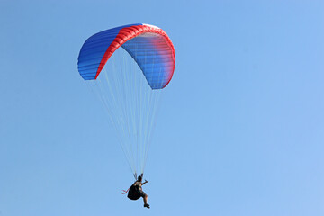 Paraglider flying wing in a blue sky	