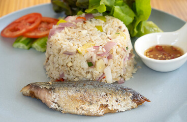 Mackerel fried rice is placed on a plate in a restaurant.