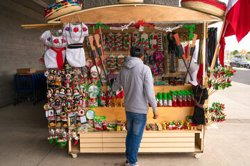 El hombre está viendo los objetos para la fiesta de independencia de México.