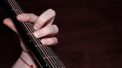 Hand putting a chord on the guitar fretboard