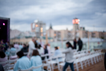 defocused background. People are watching a concert of classical music. blurred young and adult...