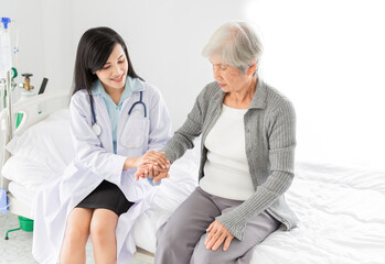 Obraz premium asian female doctor holding hand of old patient in mental health clinic, patient have a problem health in hospital, hand in hand, elderly healthcare promotion