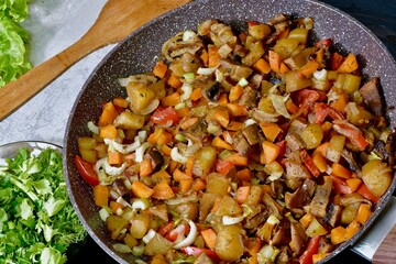 Cooking vegetables and champignons with sauce in a pan