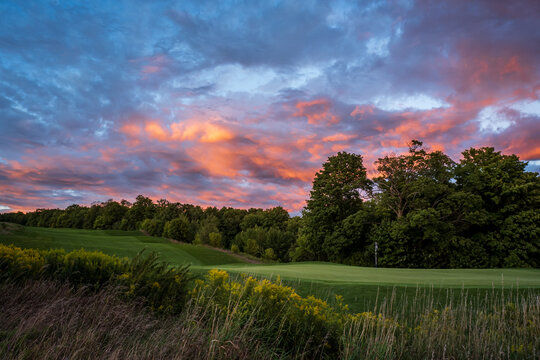 vibrant pink sunset over golf course