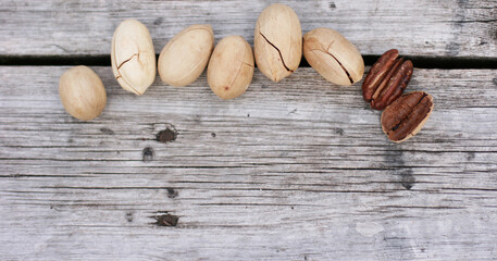 Pecan Nuts on wooden background, top view with copyspace. Close up veiw of nuts. Banner size with copy space. 