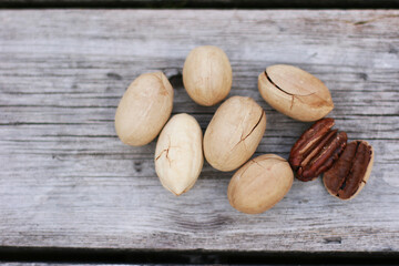 Obraz premium Pecan Nuts on wooden background, top view with copyspace. Close up veiw of nuts.