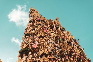 Hindu temple full of colorful ornaments against a blue sky on a sunny day.  © insomniafoto