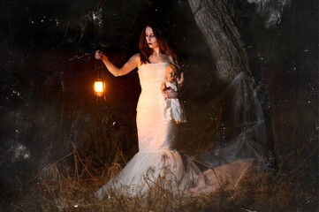 Scary woman with a lantern in night scene - Spooky image of a scary woman with dark eyes and appearance of a witch, in a white dress, holding a lit lantern and a frightening doll, in a dark night