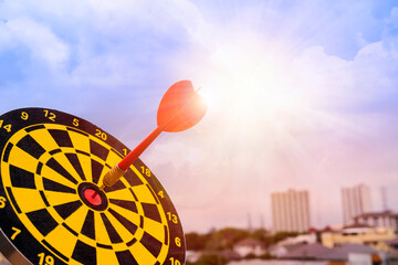 Red dart arrow hit in the target center of dartboard with sky background, Target hit in the center...