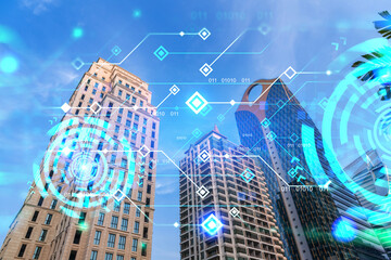 Technology hologram on low, wide angle view of glass and steel contemporary skyscrapers in financial downtown . The concept of developing coding and high-tech science. Double exposure.