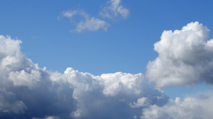 Naklejka na ściany i meble Blue sky with thick gray white clouds