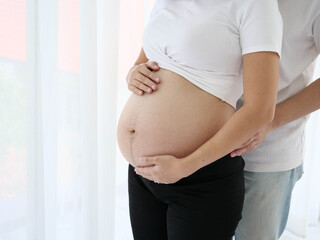 Asian pregnant woman with her husband to take care of his wife and baby happy.