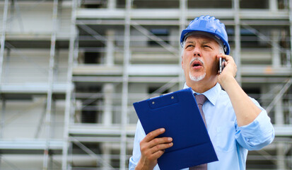 Engineer builder at construction site talking on the phone