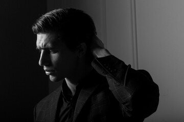 Profile of a business man dressed in black suit portrait against a dark background. Closeup portrait handsome man,