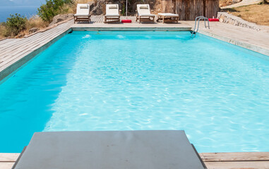 View of pool and sun loungers. Summer relaxation by the pool.
