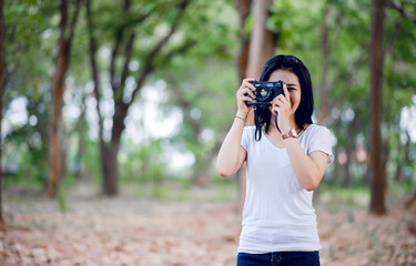 The young female photographer is happy with photography And his little camera In the natural corner