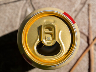 Opened can of beer or soda water with golden coloured aluminium top. Close-up view from high angle