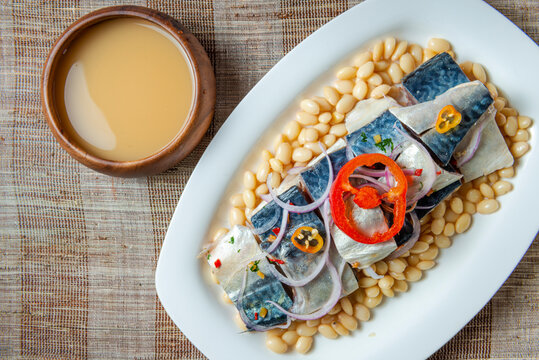 Peruvian mackerel ceviche with bean and drink chicha de jora. Top view.