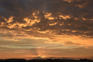 
the sunset lights up the overcast sky with color
