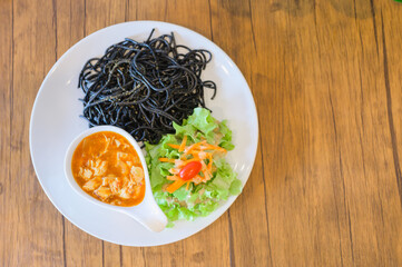 Black spaghetti with tomato chicken sauce.