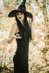 Halloween outfit for lady. Beautiful young woman in black modern dress . Halloween art design. Dark theme For Halloween Concept