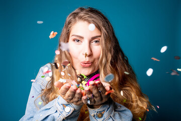 Beautiful young woman studio shot blowing confetti - Plus size caucasian female celebrating with...