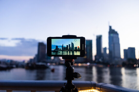 A phone on tripod recording the beautiful landscape sunset of Ho Chi Minh city or Sai Gon, Vietnam with many skyscraper buildings