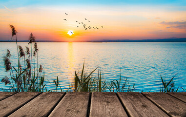Naklejka na ściany i meble paisaje de un embarcadero junto al mar en la puesta de sol