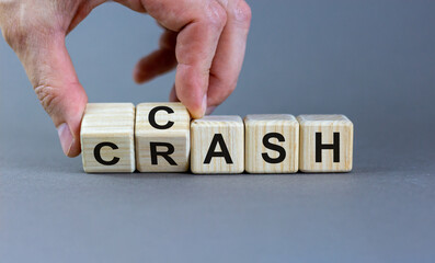 Symbol for selling stocks before a crisis. Hand turns a cube and changes the word crash to cash. Beautiful grey background, copy space. Business concept.