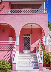 contemporary pink house arched entrance with white marble stairs and decorated door, Athens Greece