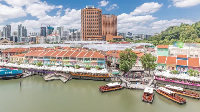 Tourist boats docking at Clarke Quay habour aerial timelapse with colorful houses. Clarke Quay is a historical riverside quay in Singapore, located within the Singapore River Planning Area.