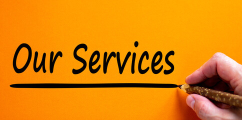 Hand writing 'our services', isolated on beautiful orange background. Business concept, copy space.
