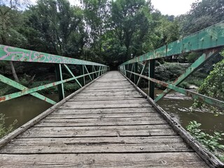 Fototapeta na wymiar Alte Holzbrücke für Fußgänger in den Wald
