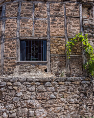 grunge iron railings secured window frame and stone wall