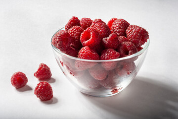 Ripe raspberries in a glass Cup on a white background. Insulation.