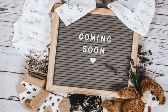 Coming soon sign. Baby announcement sign on a rustic white background. Coming soon concept. 