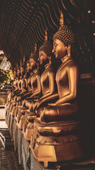 Golden Buddha statues in a Buddhist temple. - obrazy, fototapety, plakaty