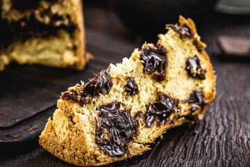 chocolate panettone isolated on rustic wooden background, space for text. Typical Christmas dessert in several countries of the world