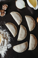 Handmade dumplings on black background.